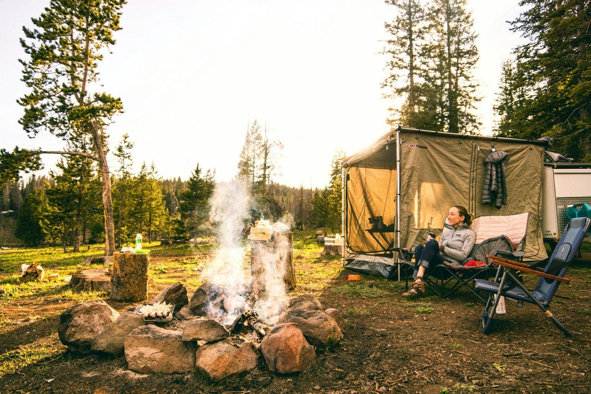 Relaxing at a car camping site with a canvas tent and campfire