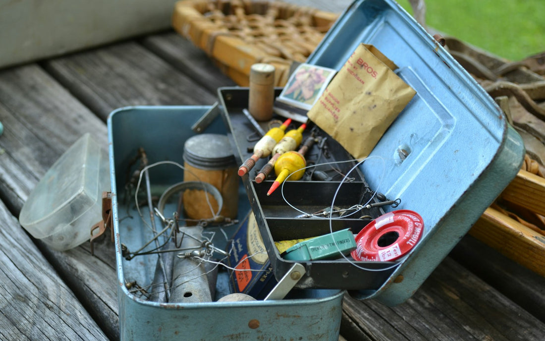 Open tackle box with hooks, line and lures on a wooden dock